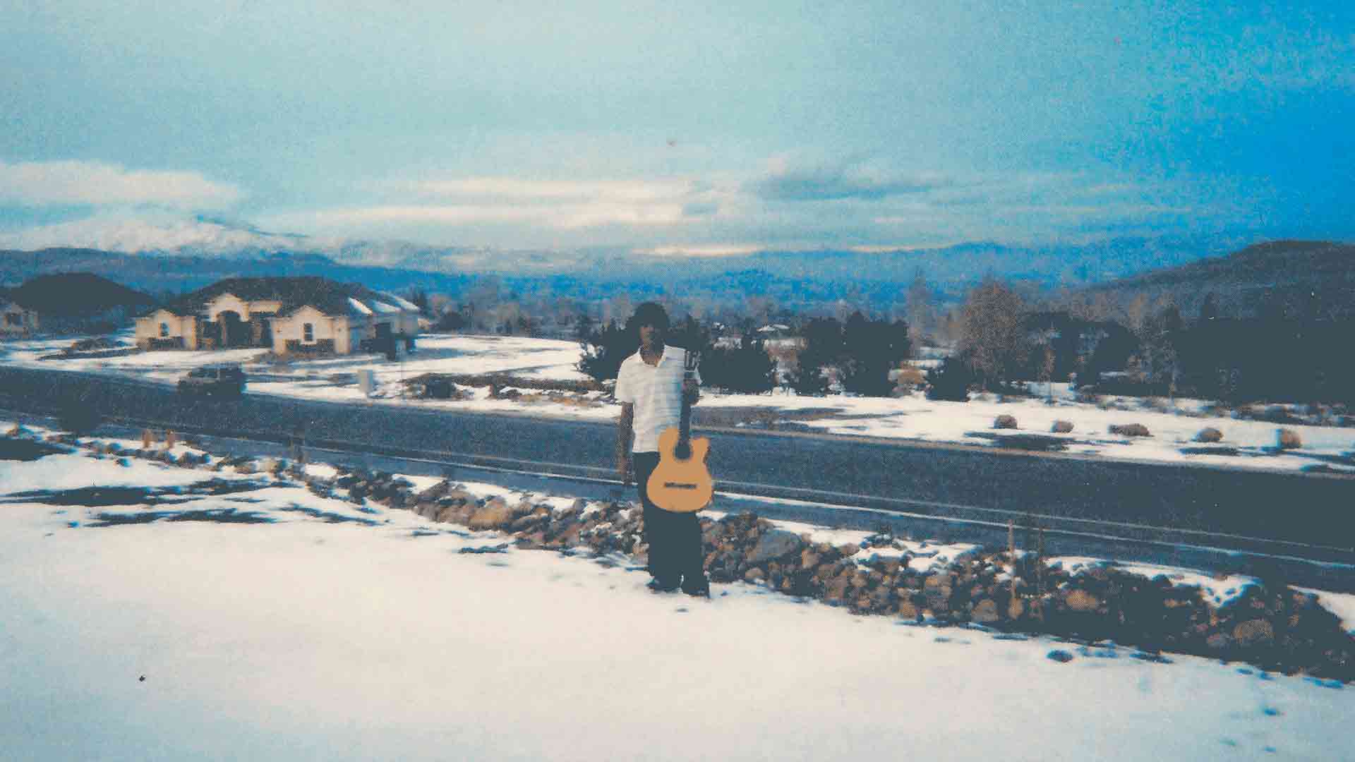 Raúl in the snow holding a guitar